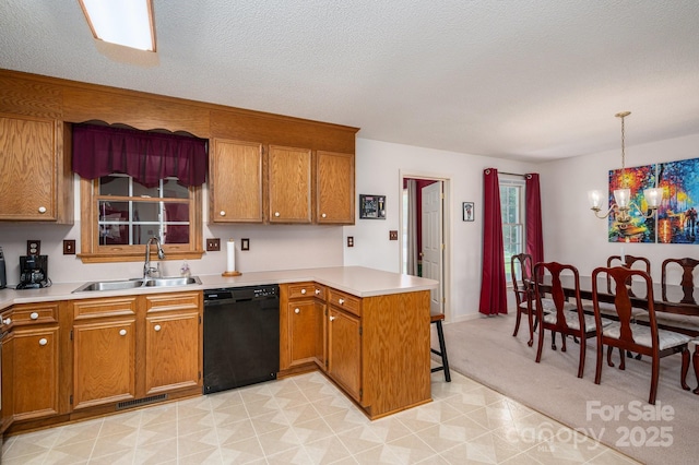 kitchen featuring a sink, brown cabinets, a peninsula, and dishwasher