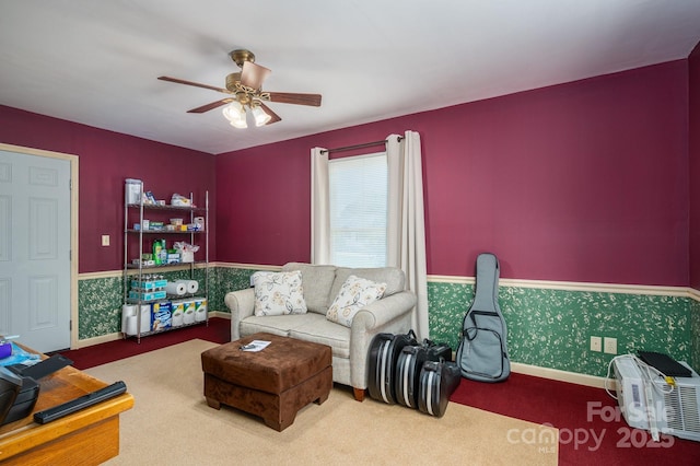 carpeted living room featuring baseboards and ceiling fan