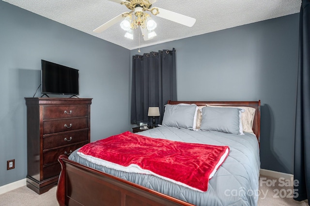 carpeted bedroom featuring a ceiling fan, baseboards, and a textured ceiling