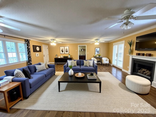 1723 Baskins Hill Rd, Heath Springs, SC 29058 - living room with a ceiling fan, a textured ceiling, a fireplace, wood finished floors, and ornamental molding