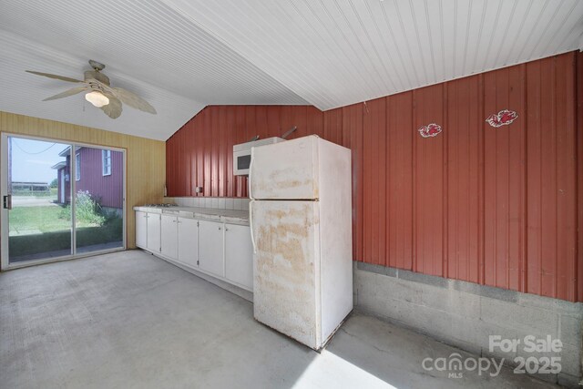 1723 Baskins Hill Rd, Heath Springs, SC 29058 - kitchen with lofted ceiling, white appliances, ceiling fan, wooden walls, and concrete floors