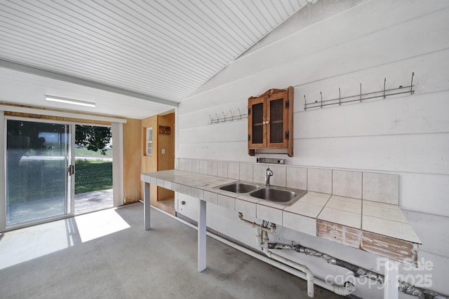 1723 Baskins Hill Rd, Heath Springs, SC 29058 - kitchen featuring glass insert cabinets, tile countertops, finished concrete floors, a sink, and vaulted ceiling