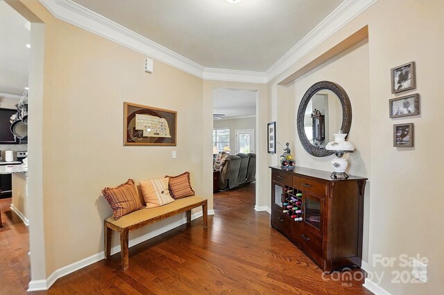 corridor featuring crown molding, baseboards, and wood finished floors