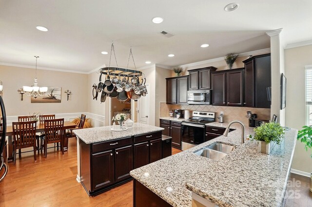 kitchen with visible vents, a center island, a chandelier, a sink, and stainless steel appliances
