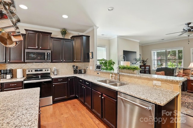 kitchen featuring plenty of natural light, open floor plan, a peninsula, and stainless steel appliances