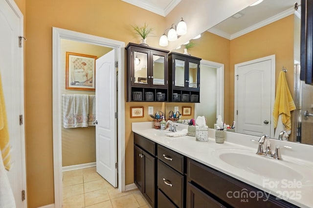 bathroom featuring a sink, tile patterned floors, crown molding, and double vanity