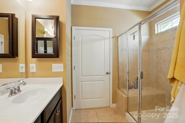 full bath featuring baseboards, ornamental molding, a stall shower, and tile patterned floors
