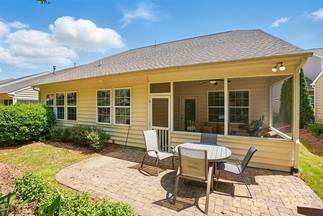 rear view of property with a ceiling fan, a shingled roof, and a patio area