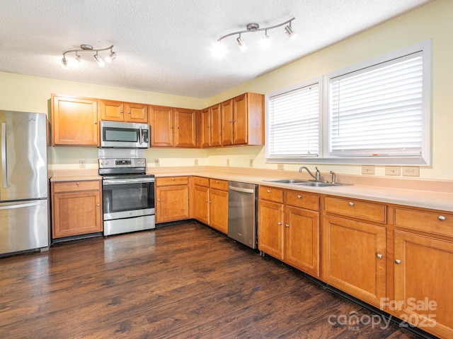 kitchen featuring a sink, appliances with stainless steel finishes, a textured ceiling, and light countertops