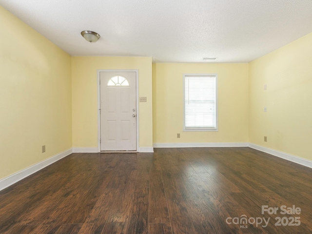 foyer entrance with baseboards and dark wood finished floors