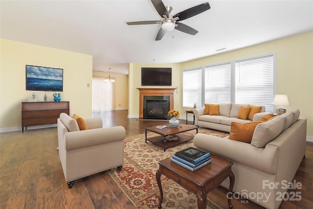 living area featuring ceiling fan, baseboards, plenty of natural light, and wood finished floors