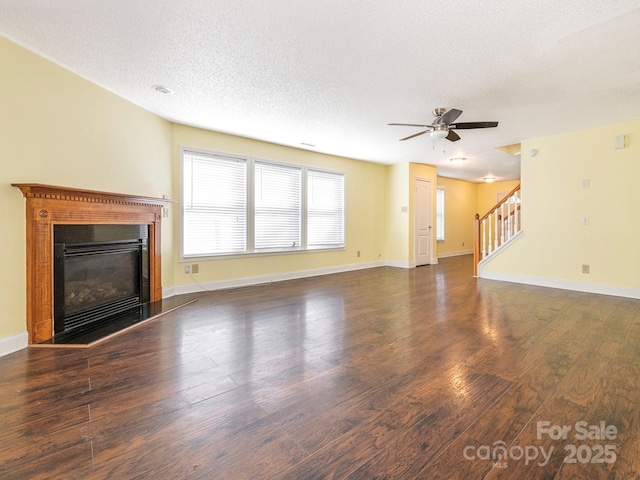 unfurnished living room featuring a textured ceiling, ceiling fan, wood finished floors, and stairway