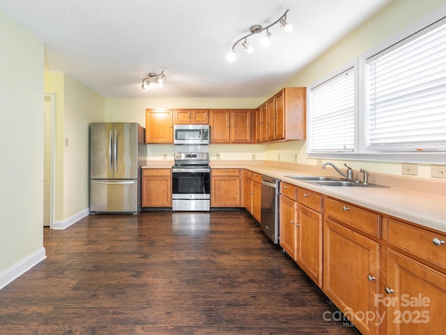kitchen with light countertops, stainless steel appliances, dark wood finished floors, and a sink
