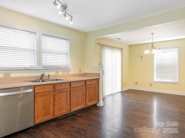 kitchen with hanging light fixtures, brown cabinets, dishwasher, a sink, and a chandelier