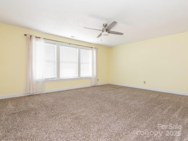 empty room with baseboards, ceiling fan, and light carpet