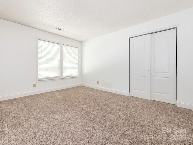 unfurnished bedroom with carpet flooring, baseboards, and a closet