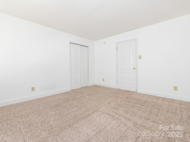 spare room with baseboards and carpet