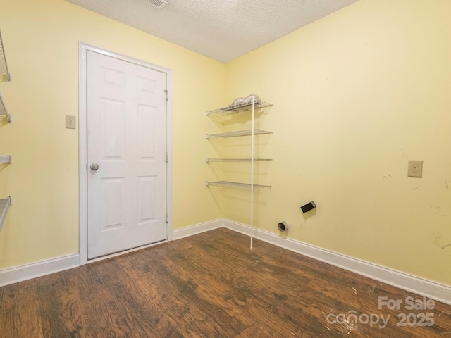 laundry area with laundry area, dark wood-style floors, and baseboards