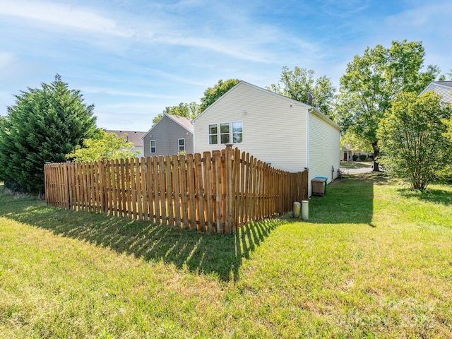 back of house featuring a lawn and fence
