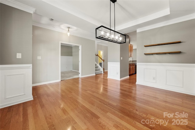 14625 Lyon Hill Ln, Huntersville, NC 28078 - unfurnished dining area with ornamental molding, wainscoting, stairway, light wood-style flooring, and a notable chandelier