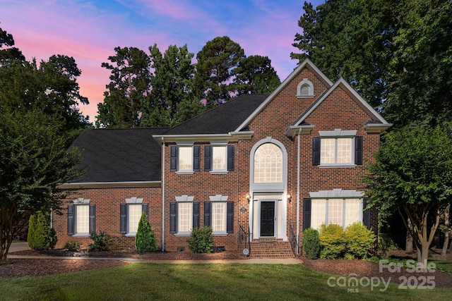 2608 Carmarthen Ct, Matthews, NC 28104 - view of front facade with brick siding, a yard, a shingled roof, and entry steps