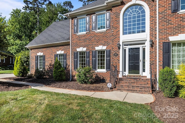2608 Carmarthen Ct, Matthews, NC 28104 - view of front of home featuring brick siding, entry steps, a shingled roof, and a front yard