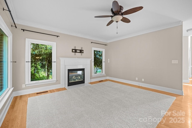 2608 Carmarthen Ct, Matthews, NC 28104 - unfurnished living room featuring crown molding, light wood-style floors, ceiling fan, and a fireplace with flush hearth