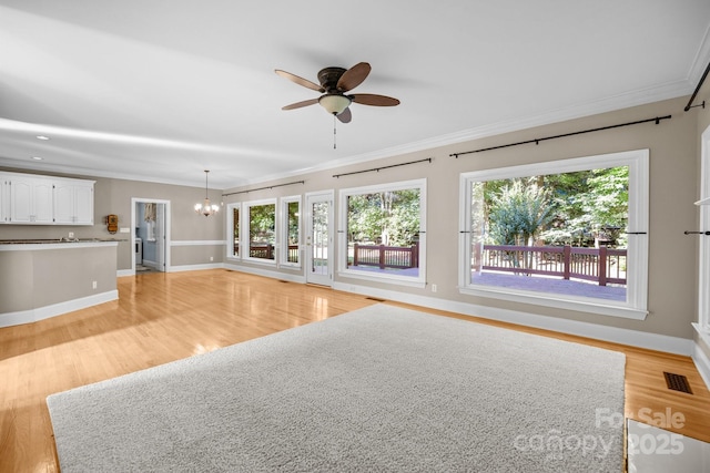 2608 Carmarthen Ct, Matthews, NC 28104 - unfurnished living room featuring crown molding, light wood-type flooring, ceiling fan, and a chandelier