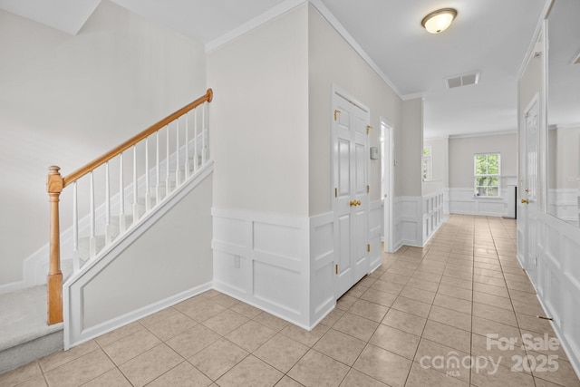 104 Clydesdale Ct, Matthews, NC 28104 - foyer entrance featuring light tile patterned flooring, ornamental molding, a decorative wall, stairs, and wainscoting