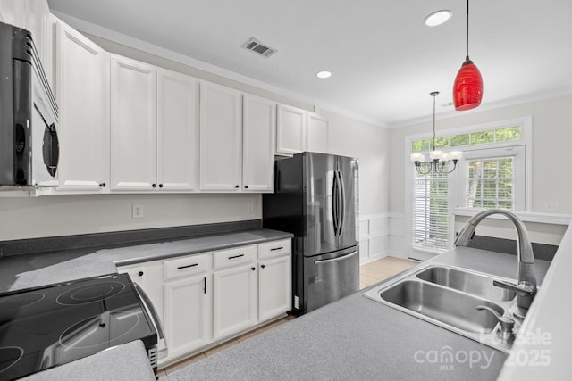 104 Clydesdale Ct, Matthews, NC 28104 - kitchen with stainless steel appliances, white cabinetry, hanging light fixtures, a chandelier, and ornamental molding