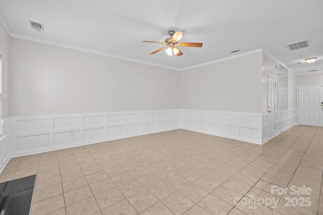 104 Clydesdale Ct, Matthews, NC 28104 - spare room featuring light tile patterned floors, a ceiling fan, ornamental molding, a decorative wall, and wainscoting
