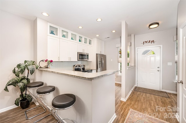 15318 Coventry Court Ln, Charlotte, NC 28277 - kitchen with white cabinets, appliances with stainless steel finishes, glass insert cabinets, and light wood-type flooring