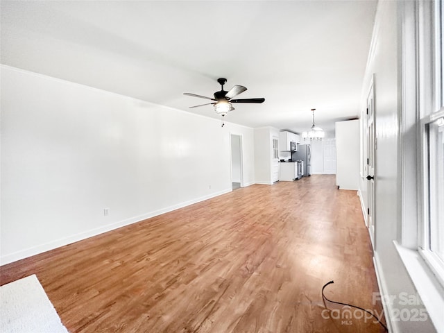 326 N Greenbriar Rd, Statesville, NC 28625 - unfurnished living room featuring light wood-style floors, crown molding, baseboards, and ceiling fan with notable chandelier