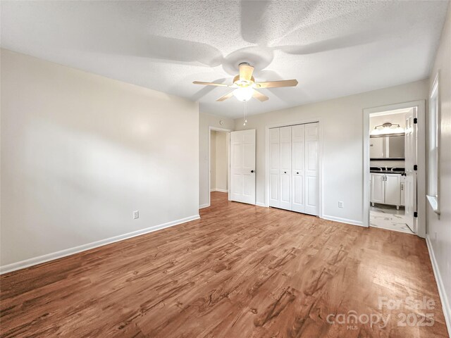 326 N Greenbriar Rd, Statesville, NC 28625 - unfurnished bedroom featuring baseboards, a textured ceiling, wood finished floors, and a closet