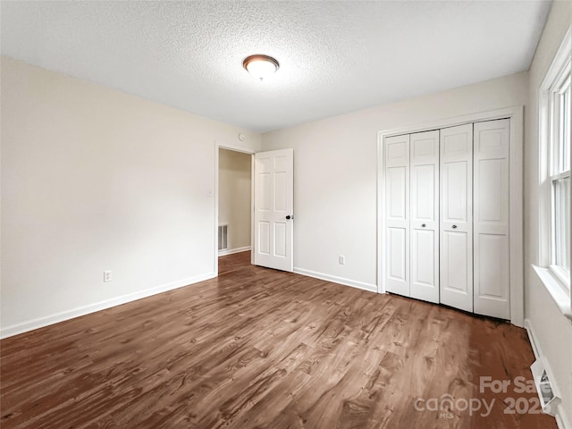326 N Greenbriar Rd, Statesville, NC 28625 - unfurnished bedroom featuring a textured ceiling, baseboards, a closet, and wood finished floors