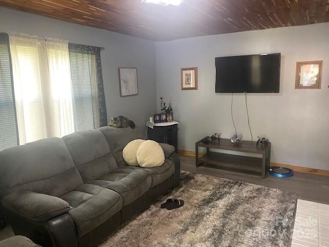 living room featuring baseboards, wood finished floors, and wooden ceiling