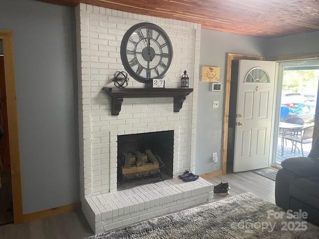 living room with wood ceiling, baseboards, wood finished floors, and a fireplace