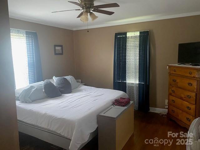 bedroom with ceiling fan, ornamental molding, and wood finished floors