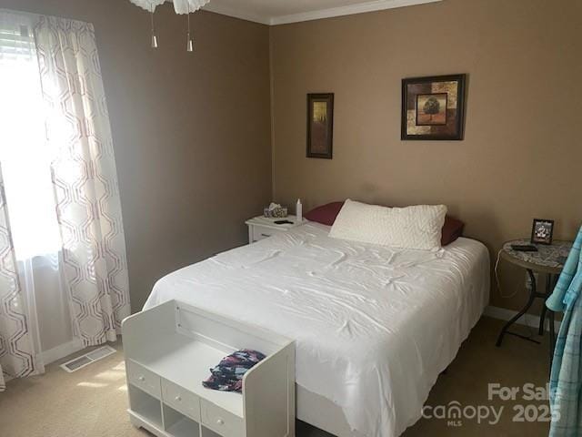 bedroom with baseboards, multiple windows, visible vents, and light carpet