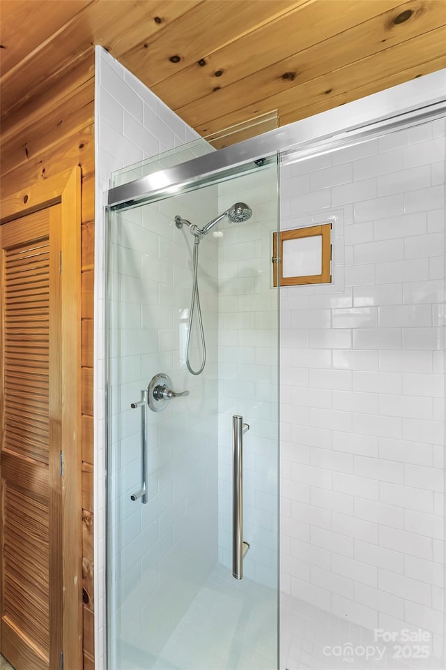 bathroom featuring wooden ceiling and a shower stall