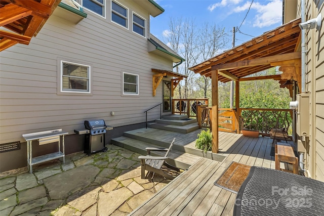 wooden deck featuring a grill and a patio area