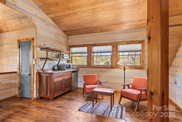 sitting room featuring wooden walls, wood ceiling, wood finished floors, and lofted ceiling