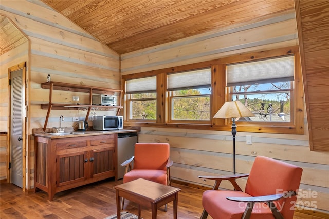 sitting room with wooden walls, wooden ceiling, wood finished floors, and lofted ceiling