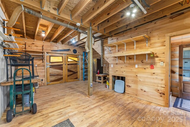 basement with wooden walls and wood-type flooring