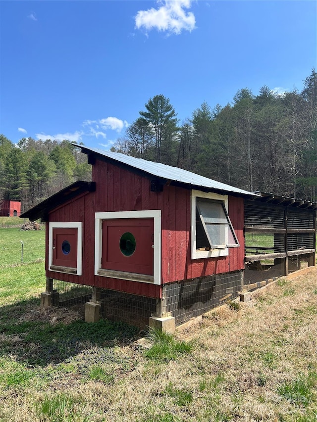 view of poultry coop with a yard and a wooded view