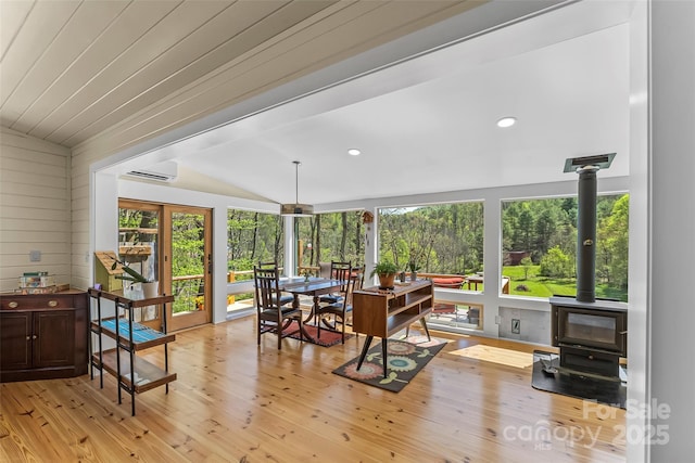 sunroom / solarium featuring a wood stove and a wall unit AC