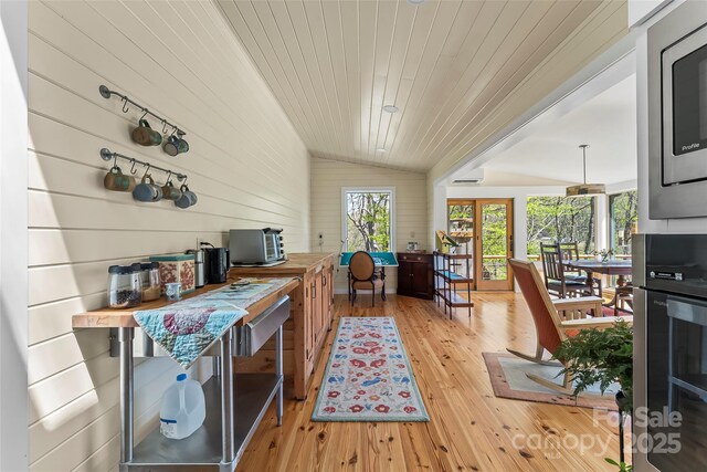 interior space featuring light wood-style floors, wood walls, lofted ceiling, and wooden ceiling