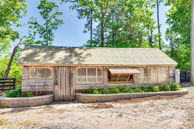 view of front of house featuring metal roof and fence