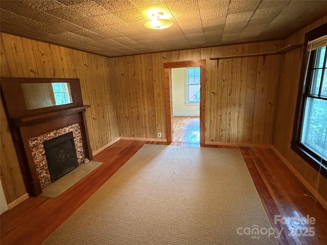 633 Ridge Rd, Marion, NC 28752 - unfurnished living room featuring wooden walls, baseboards, a fireplace, and wood finished floors