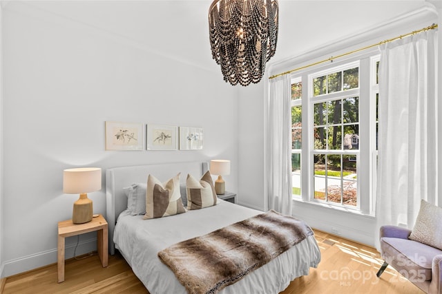2509 Bay St, Charlotte, NC 28205 - bedroom featuring a chandelier, wood finished floors, and baseboards